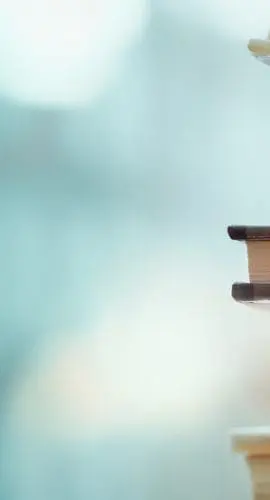 A stack of books with various colored covers is set against a blurred background.