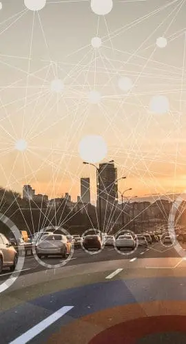 A highway at sunset is overlaid with digital network symbols representing connectivity or communication.