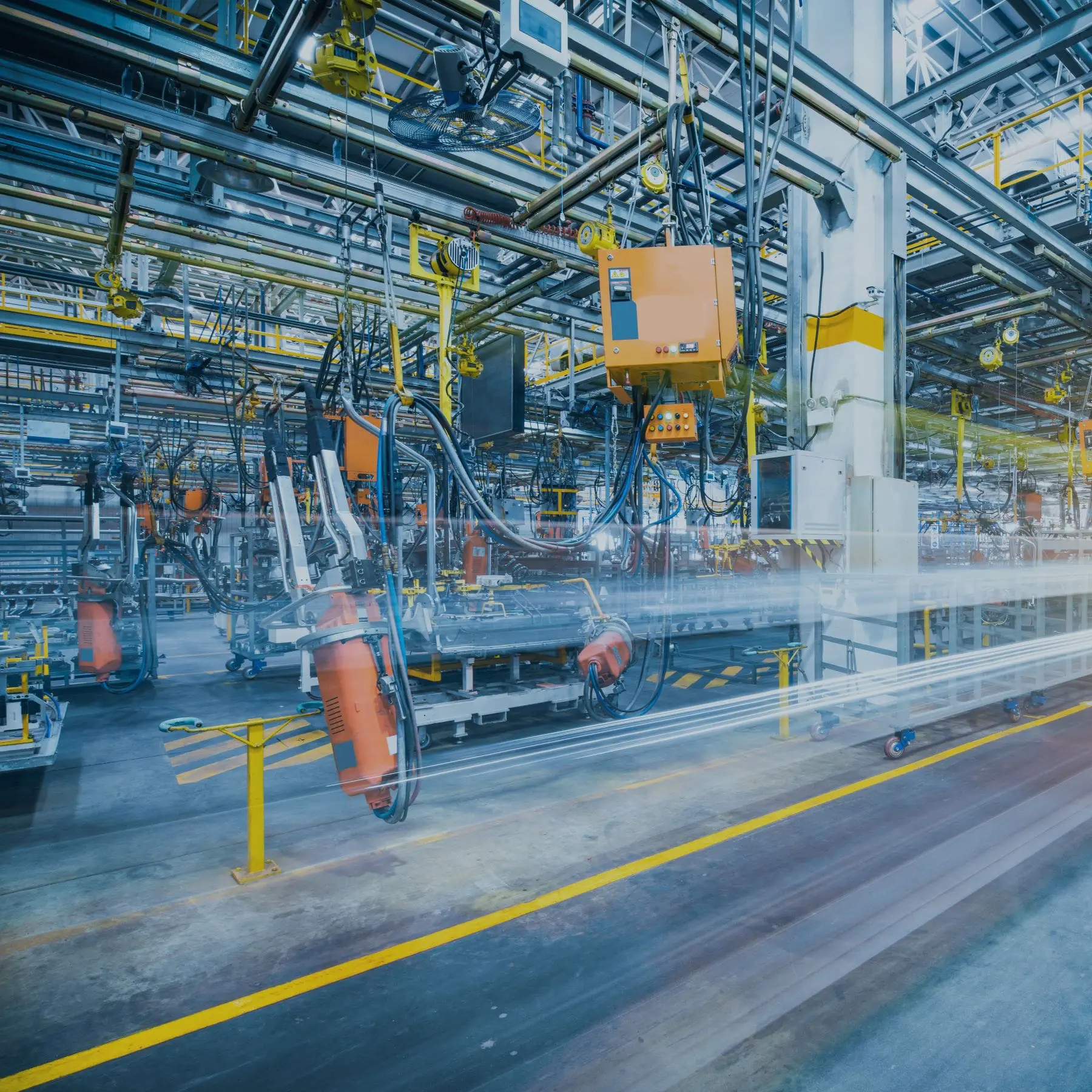 A busy factory floor with machinery and conveyor belts, suggesting a highly industrialized setting with automation.