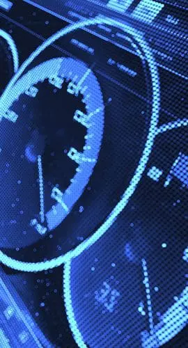 A close-up view of a digital car dashboard with glowing blue speedometers and dials.