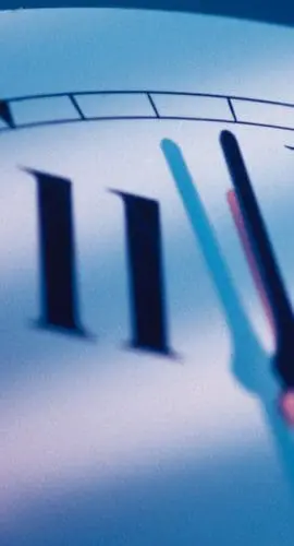 A close-up view of a clock showing the time approaching midnight.