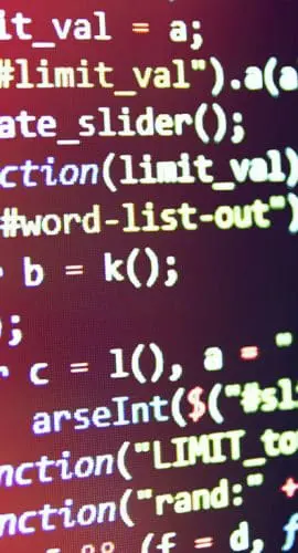 A close-up view of a computer screen displays a colorful code editor with various lines of programming code.