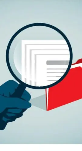 A magnifying glass is being held over a folder with papers, emphasizing scrutiny or examination.