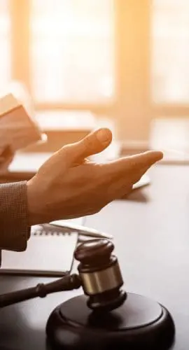 Individuals are engaged in a discussion with a gavel on the table, suggesting a legal or formal setting.