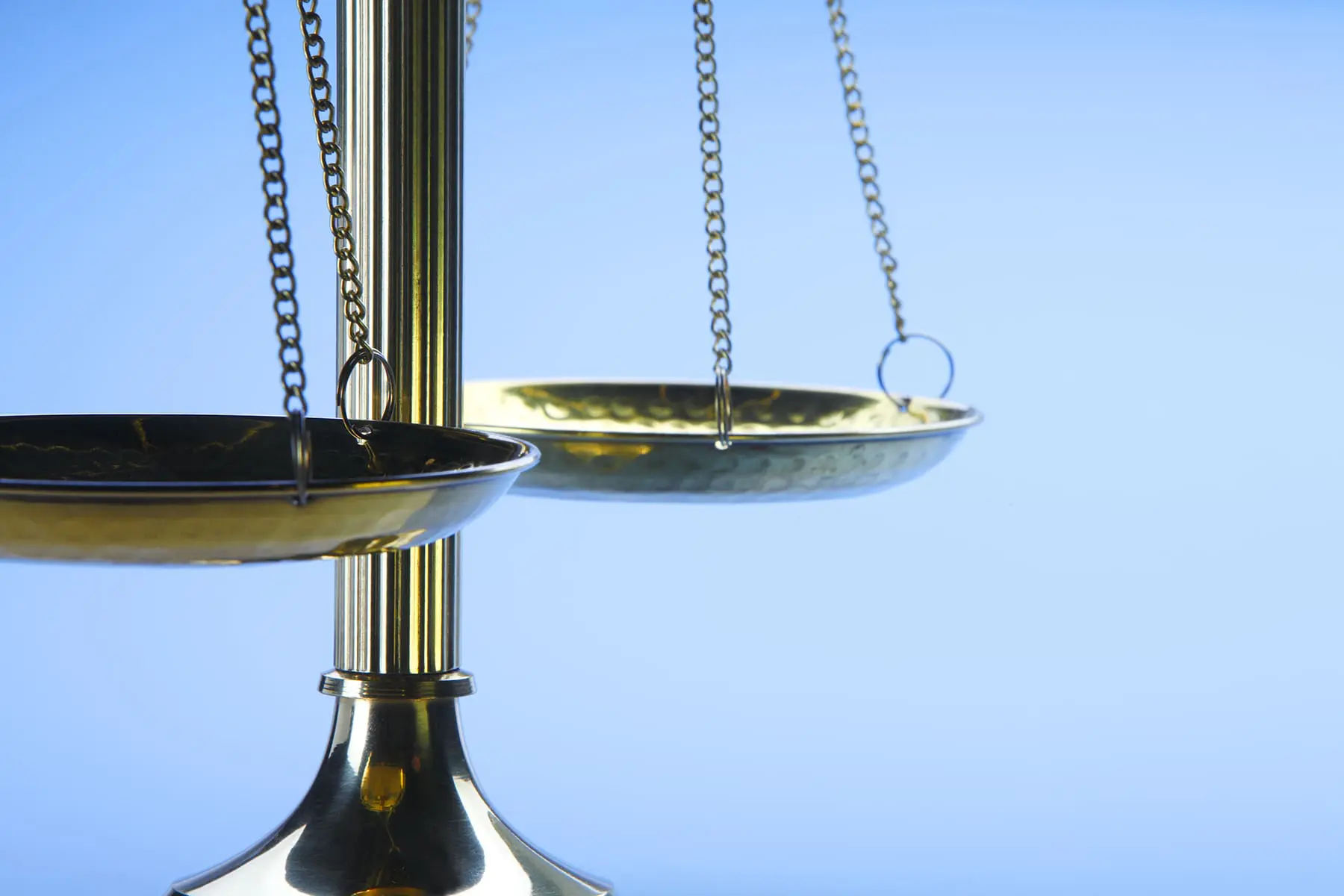 A traditional balance scale with empty pans against a blue background.