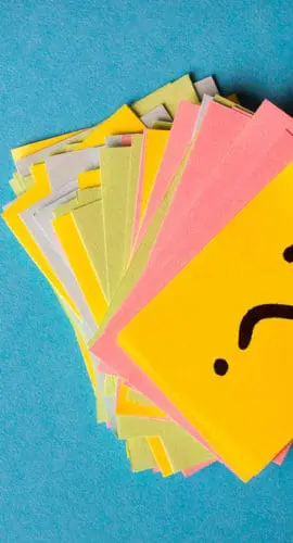A stack of colorful sticky notes with a question mark on the top note is arranged against a blue background.