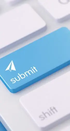 A close-up of a modern white keyboard with a blue "submit" key highlighted and an arrow cursor icon pointing upwards.