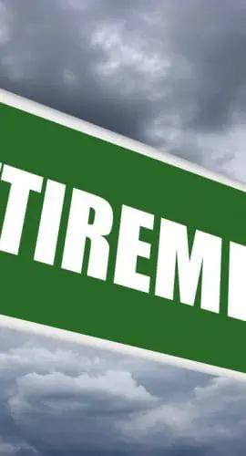 A green road sign with the word "RETIREMENT" on it against a cloudy sky backdrop.