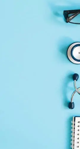 A stethoscope, a pair of eyeglasses, and a notebook with a pen are arranged on a light blue background.