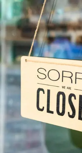 A sign hangs on a door with the message "SORRY, CLOSED."