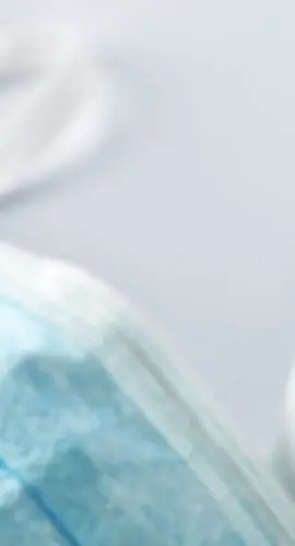 A face mask lies next to a spray bottle.