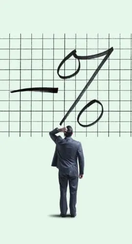 A man stands looking at a large grid chart with a negative percentage symbol drawn on it.