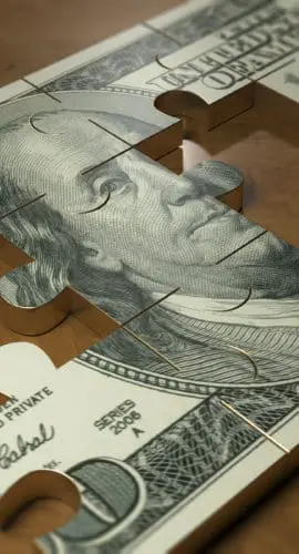 A jigsaw puzzle featuring a partially completed image of a hundred-dollar bill.