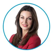 A woman with long brown hair and wearing a red blazer is smiling.