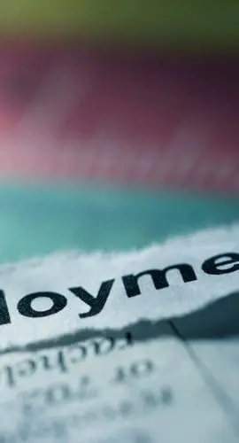 A newspaper shows a torn section with the word "Employment" prominently displayed.