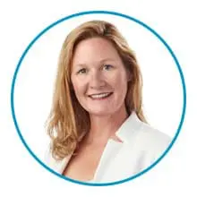 A woman with shoulder-length blonde hair is smiling, wearing a white jacket, and is framed by a blue circle.