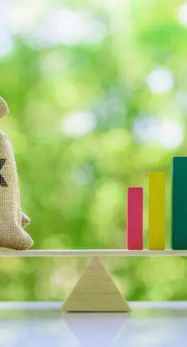 Growth in Income tax collection, tax payer increasing concept : Tax bags, rising bar graph on a basic balance scale, depicting fiscal tax revenue gain and meet target after economic policy and stimulus plan