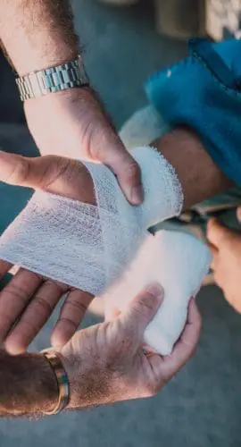 Person applying bandage on another person s hand