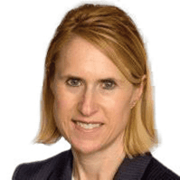 A woman with shoulder-length blonde hair is wearing a dark blazer and smiling slightly.