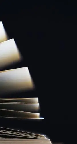 Macro view of book pages. Open book, white sheets on dark black background. Education background, copy space