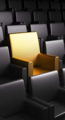 One golden seat in an empty auditorium surrounded by rows of black seats - QSBS Section 1202 Small Business Tax Exclusion