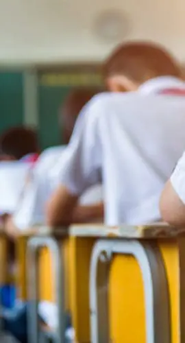 Rear view of middle school students studying in classroom