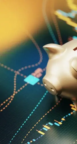 Gold colored piggy bank sitting over a bar graph. Selective focus. Horizontal composition with copy space. Savings and finance concept.