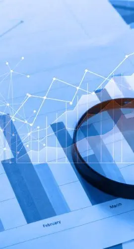 Magnifying glass and documents with analytics data lying on table,selective focusMagnifying glass and documents with analytics data lying on table,selective focus