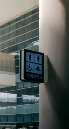 Signboard of public toilet placed on wall