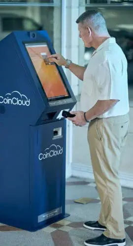 Man buying cryptocurrency at atm