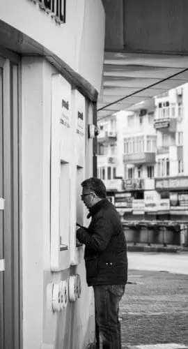 Man using atm machine on street
