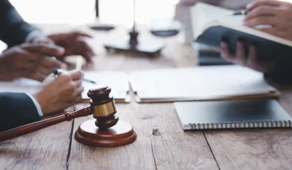 Close-up of a judge with a hammer against the background of professional lawyer talking about a lawsuit. professional lawyers discussing legal case.