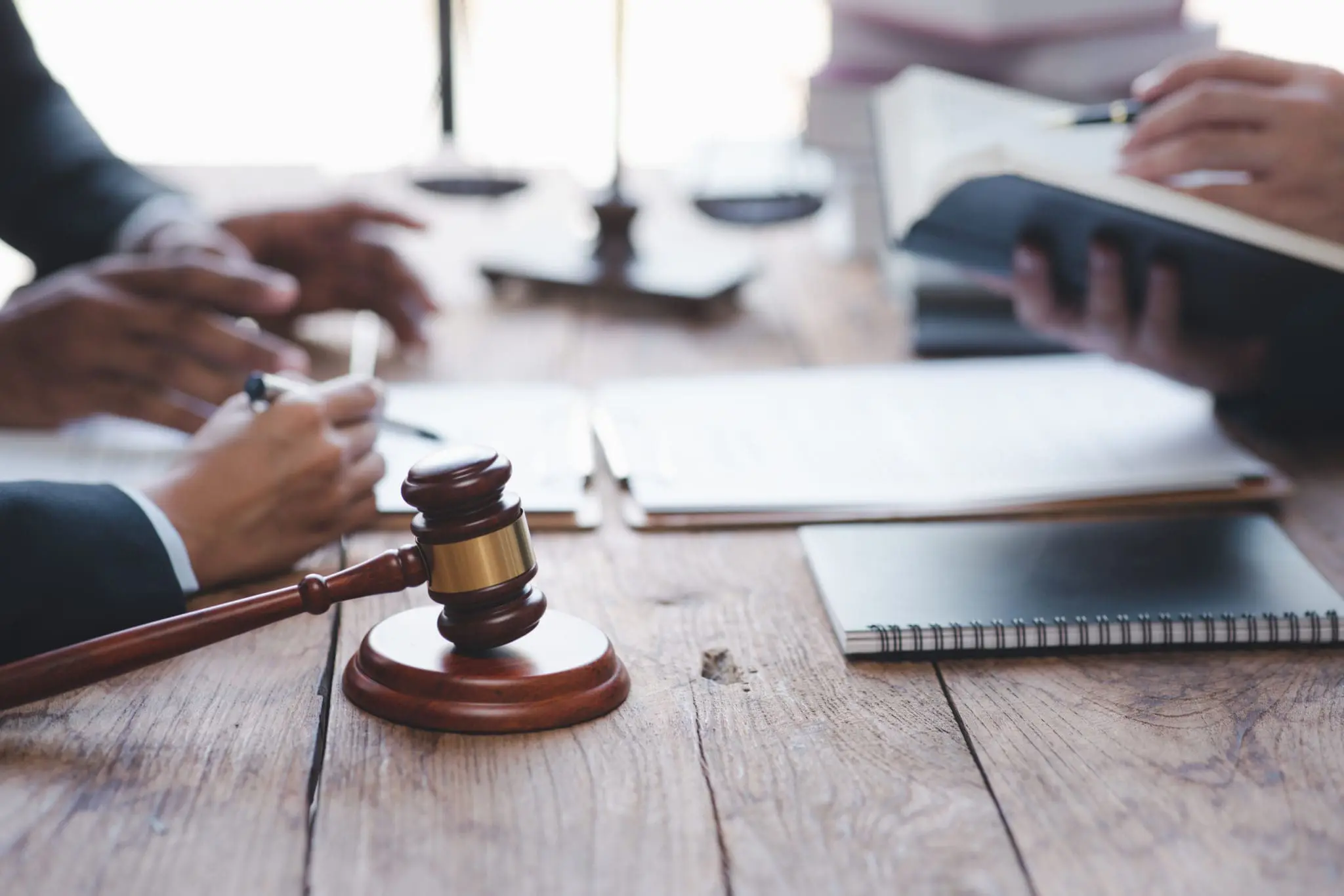 Close-up of a judge with a hammer against the background of professional lawyer talking about a lawsuit. professional lawyers discussing legal case.