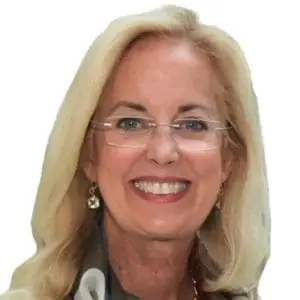 A smiling woman with long blonde hair, wearing glasses and earrings.