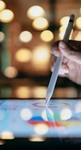 A businessperson is using a stylus to edit work reports on a tablet computer, which, combined with a mobile device, allows them to work more smoothly.