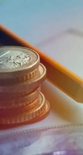 The real estate or residential concrete and wooden frame construction 3d model on blueprints and house the keys to the apartment a stack of coins.