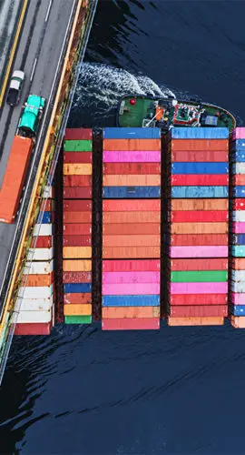 shipping containers traveling under bridge global economy