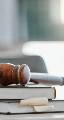 Justice, gavel and law books on table in office for court trial, legislation or fair constitution by judicial system. Firm, closeup and legal hammer by information for corporate case in workplace.