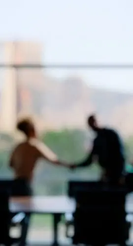 Blurred image of people in a business setting. shaking hands. Family Office Services
