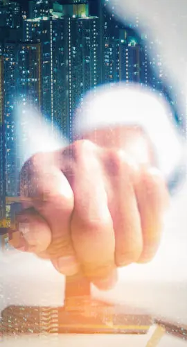 Double exposure of an “Approved” stamp over permit documents and a nighttime city skyline, symbolizing commercial real estate deal approvals and legal compliance.