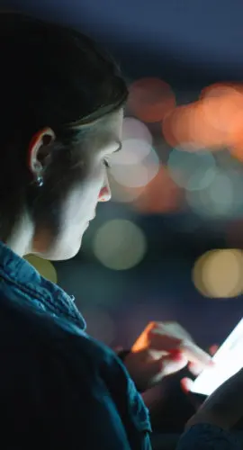 Outdoor, night and woman with smartphone, screen and typing with digital app and texting a contact. City lights, evening or email with person, message or cellphone with social media, tech or internet