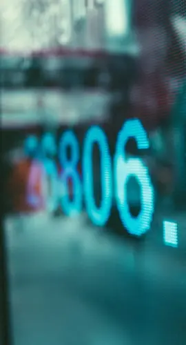 Close-up of a digital stock market display with real-time financial data in an urban setting, symbolizing market dynamics in commercial real estate finance.