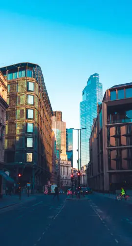 Vibrant city street flanked by historic and modern buildings under a clear blue sky