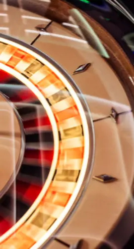 A mesmerizing visual capturing a colorful roulette wheel in motion, reflecting vibrant lights. The dynamic scene exudes excitement, emphasizing themes of luck, gambling, and the thrill of casino gaming.