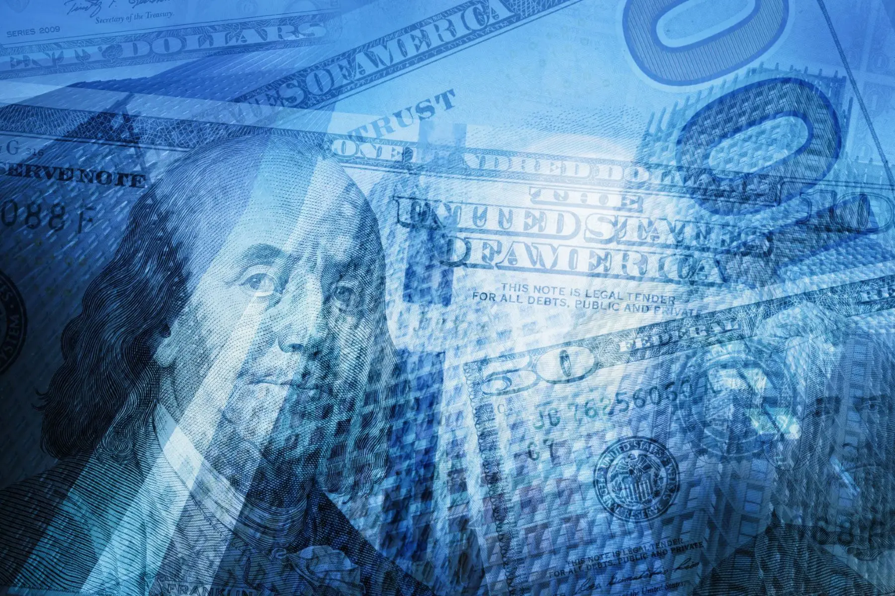 Overlay of U.S. $50 and $100 bills in blue tones with the silhouette of high-rise financial institutions in the background.