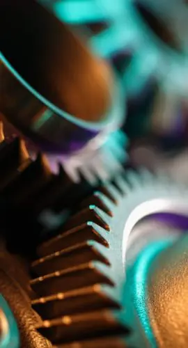 Close-up of interlocking metal gears symbolizing manufacturing technology, labor law, data privacy, and regulatory compliance in the industry.