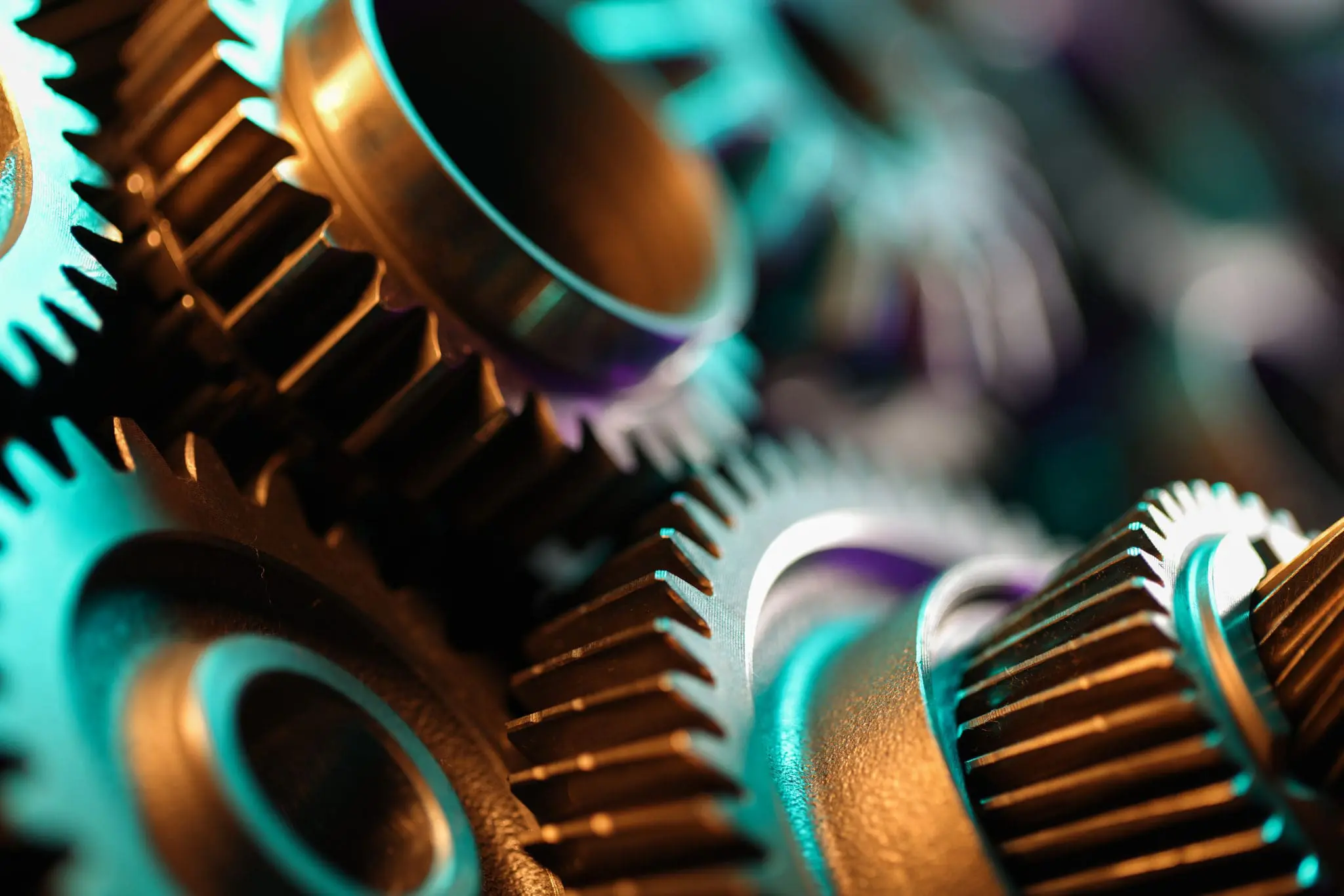 Close-up of interlocking metal gears symbolizing manufacturing technology, labor law, data privacy, and regulatory compliance in the industry.
