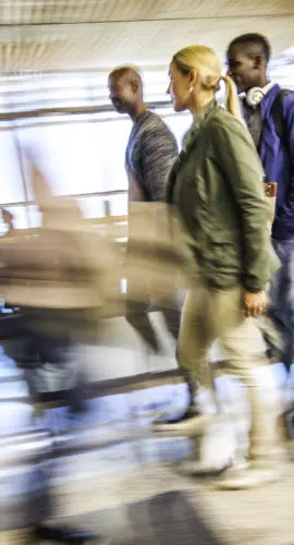 Defocused photo of people walking through an airport lobby.