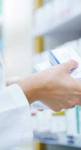 Doctor, hands or shelf with medication at pharmacy for inventory, stock or pharmaceutical service. Closeup, healthcare employee or pharmacist with box or medical product for side effect at drug store
