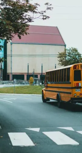 Yellow school bus driving on urban street